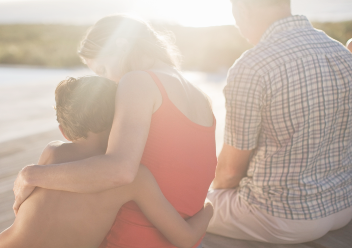 Famille devant un coucher de soleil vu de dos