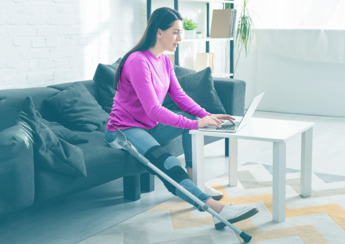 femme blessée avec plâtre sur ordinateur